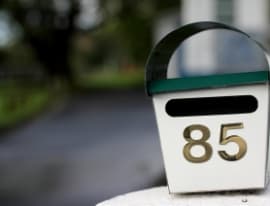 Staff measuring a custom mailer box to minimise postage costs