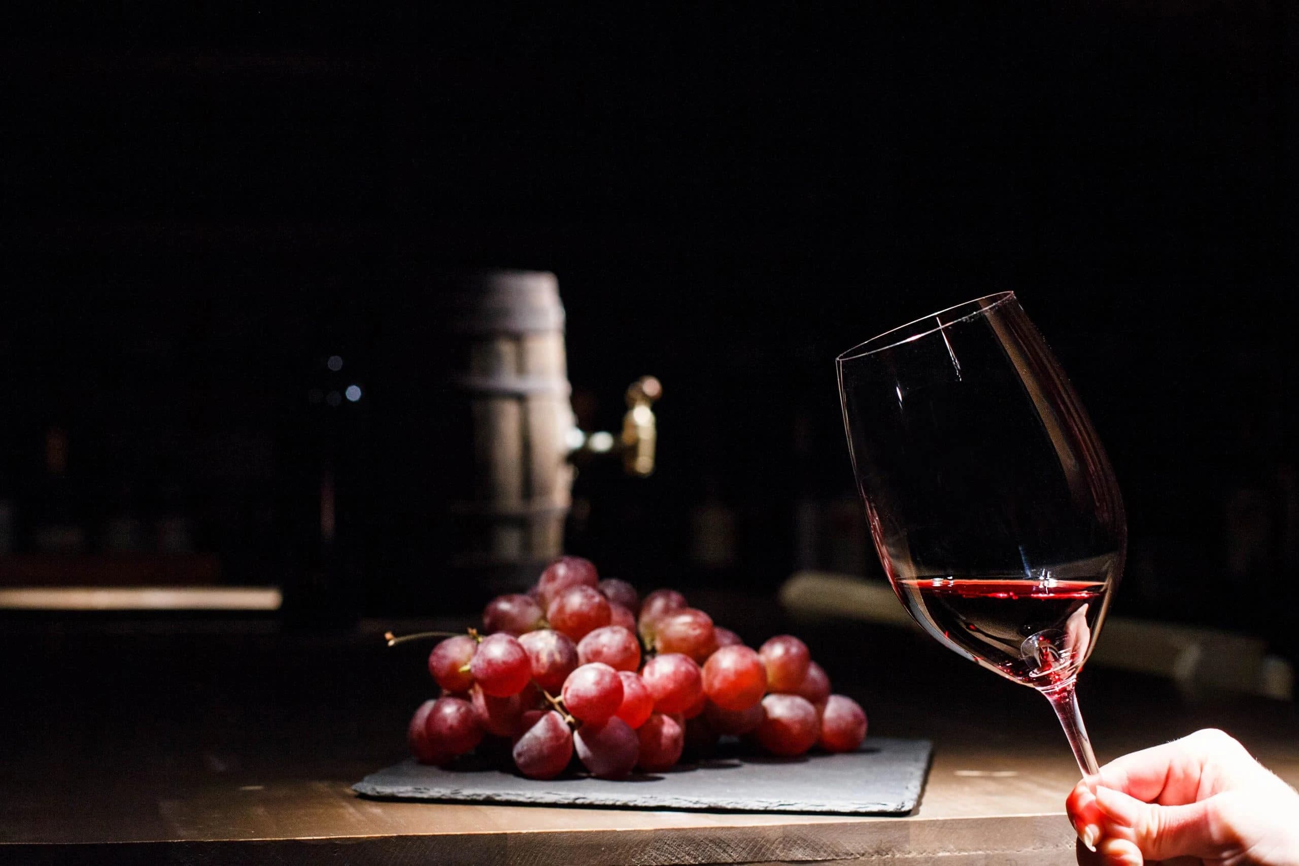 /images/packaging-solutions/wine-box-packaging/woman-holds-glass-wine-before-bunch-grape-lying-black-plate.webp